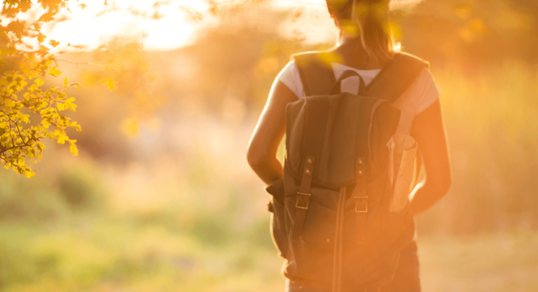 Mujer con mochila caminando sola, simbolizando una etapa de duelo y el inicio de su proceso de sanación emocional